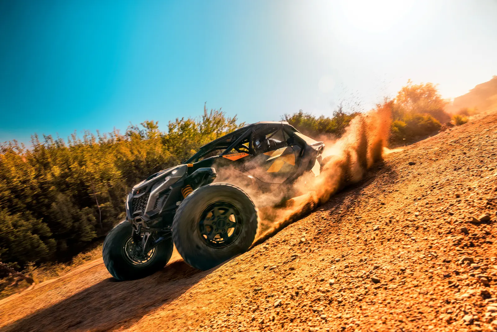 Can-Am Maverick R kör uppför en grusbacke i motljus